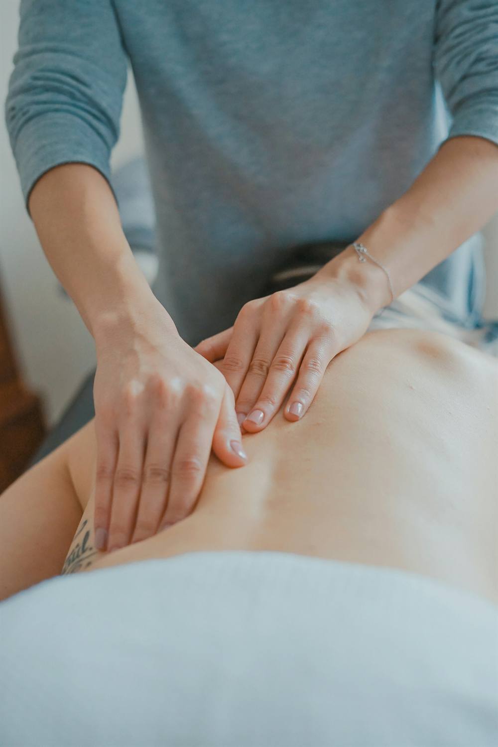 Therapist working slowly down the back with the heel of the hand