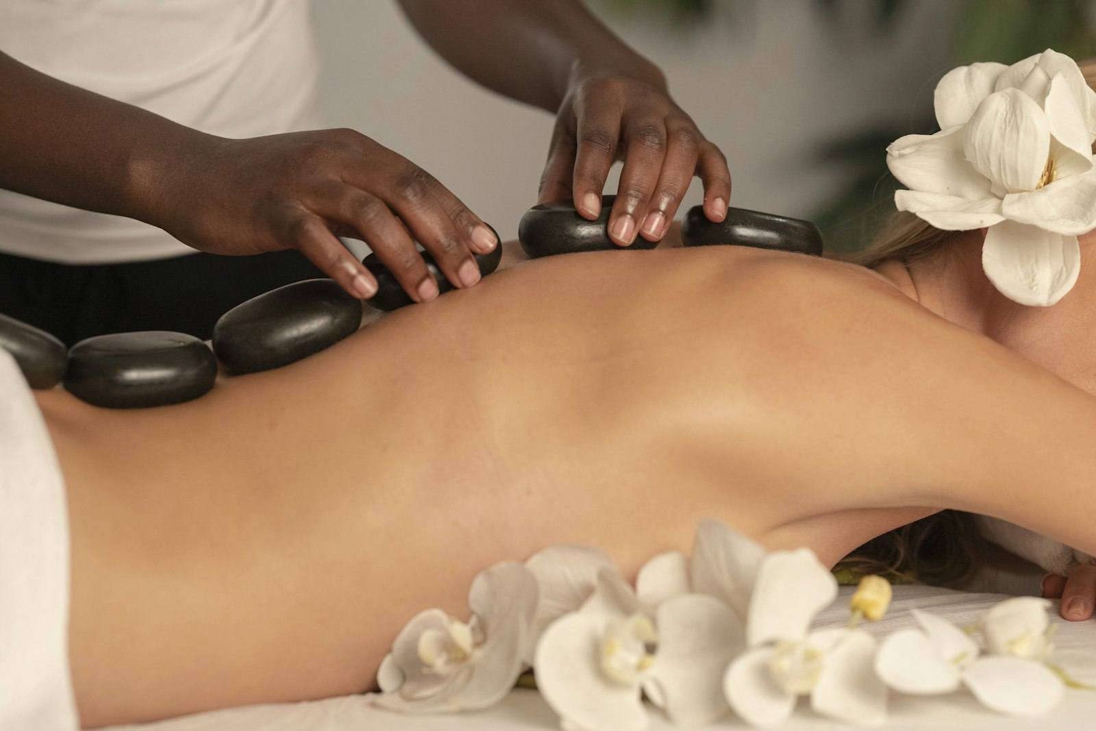 Heated basalt stones laid along a client’s spine during a hot stone massage